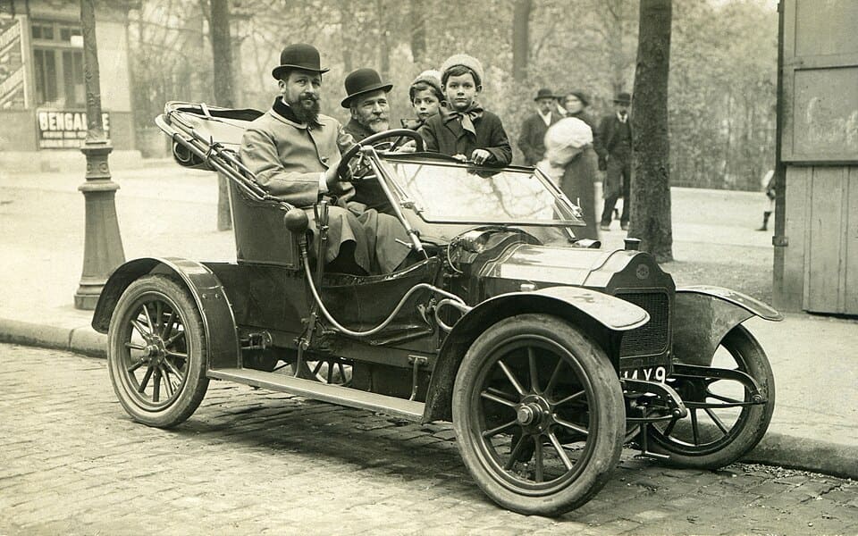 Photograph of 2 men and 2 children in an automobile, Paris, 1910